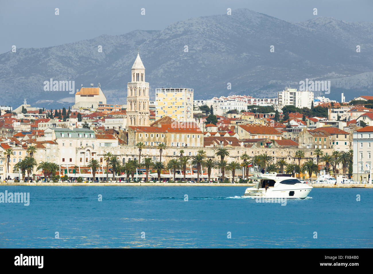 Ein Motorboot fährt auf der Promenade von Split Riva mit dem Diokletian Palast und Glockenturm im Hintergrund Stockfoto