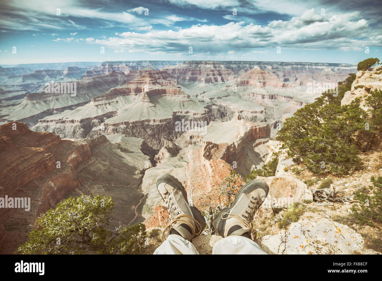 Retro-alte film stilisierte Beine mit Wanderschuhe am Rande des Grand Canyon, geringe Schärfentiefe Feld, aktiven Urlaub abgenutzt Stockfoto