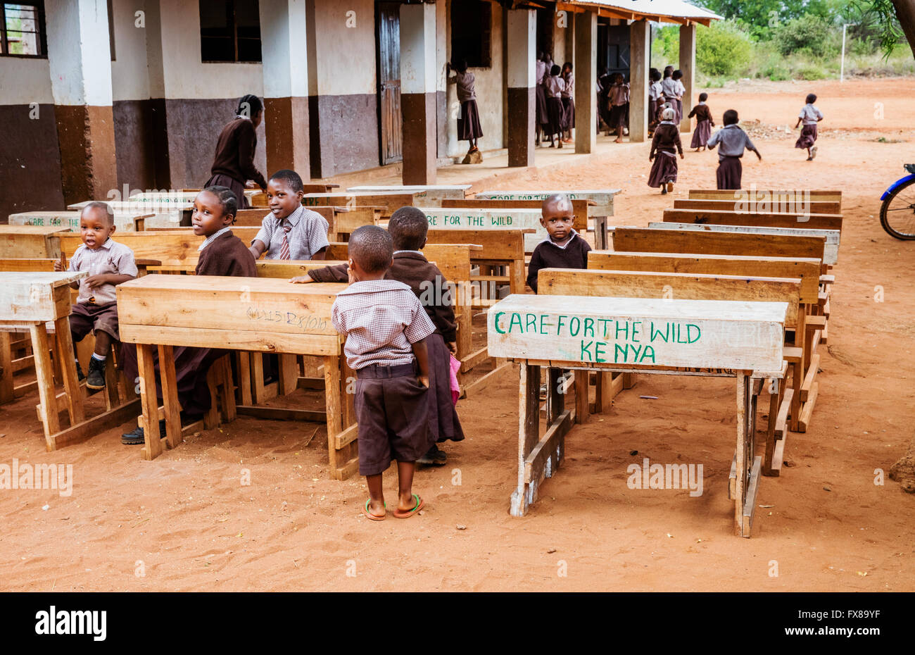 Kinder an Nächstenliebe Schreibtischen inmitten im freien einer Grundschule in der Nähe von Voi in Südkenia Stockfoto