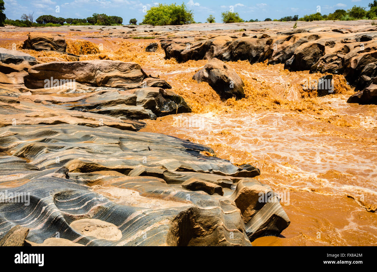 Lugards fällt am Galana River im Tsavo National Park East Kenia gefärbt rot mit Schlick nach starkem Regen Stockfoto