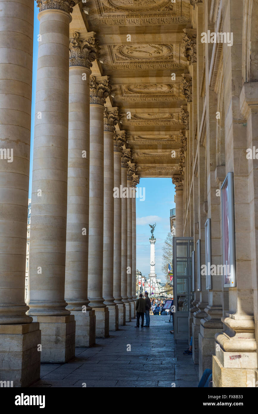 Menschen in der Säulenhalle des Grand Theatre de Bordeaux mit dem Place des Quinconces im Hintergrund. Bordeaux, Frankreich Stockfoto