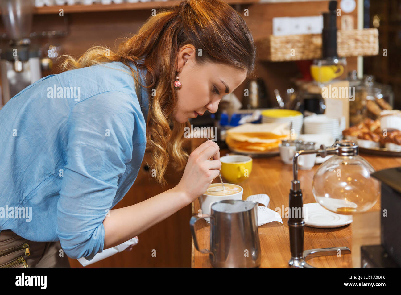 Barista-Frau in Café Latte Kunst zu machen Stockfoto