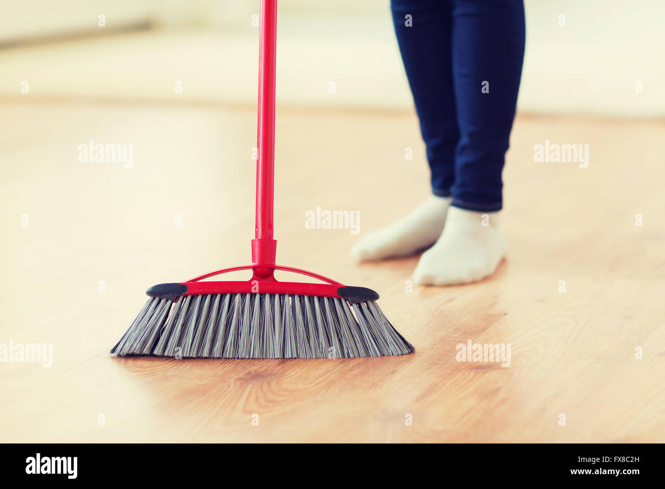 Nahaufnahme von Frau Beine mit Besen fegt Stock Stockfoto
