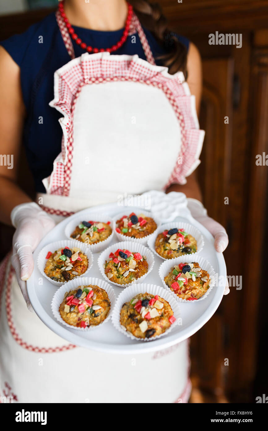 Junge Frau mit einem Tablett mit Cupcakes in der Küche Stockfoto