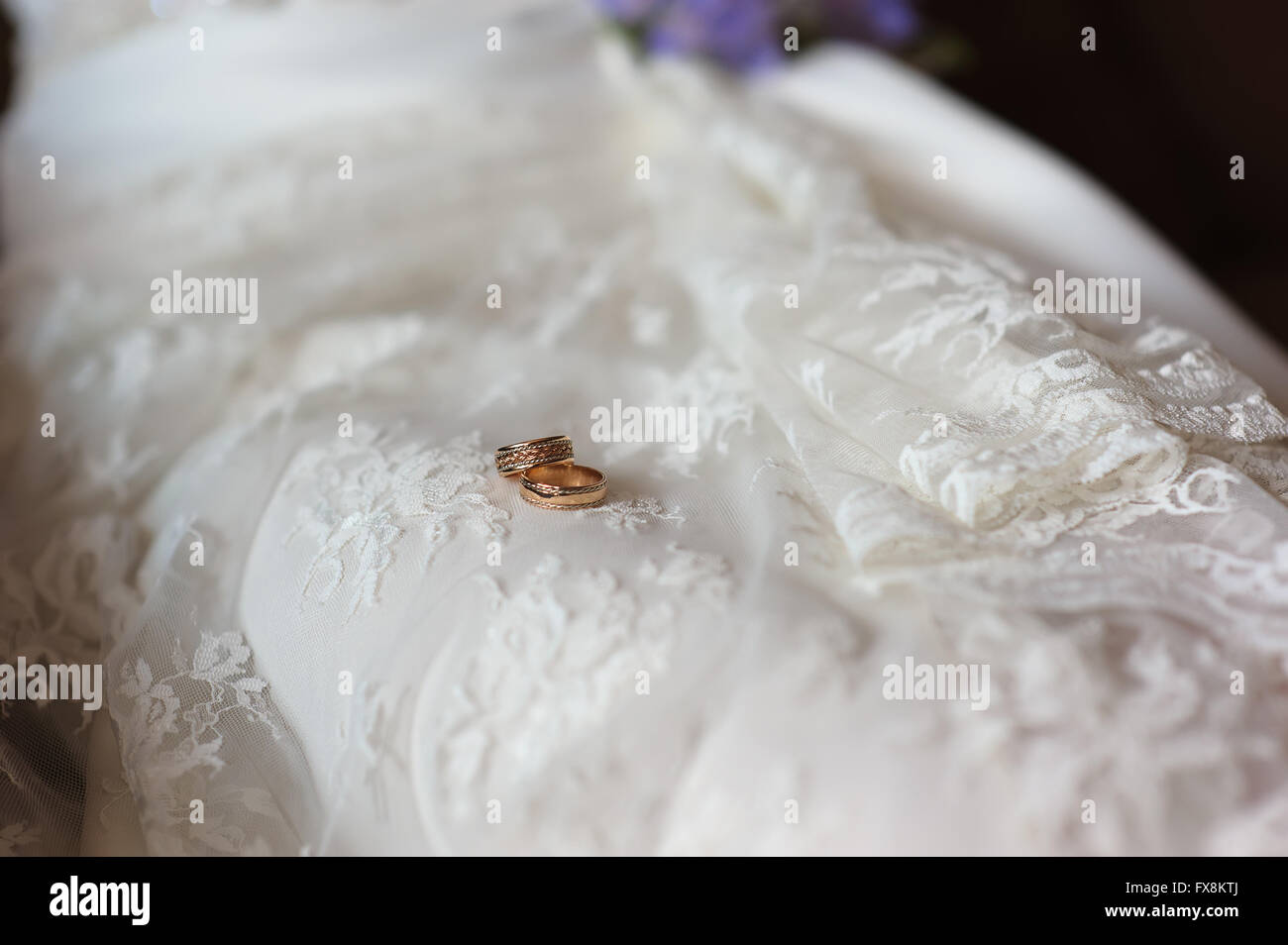 Goldene zwei Trauringe auf Spitze weißes Brautkleid. Stockfoto