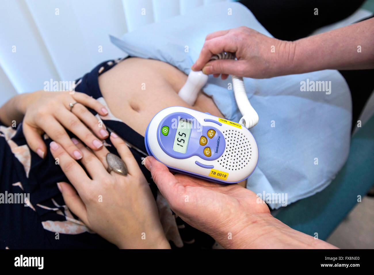 Hebamme mit einer Sonicaid eine fetale Herz-Doppler auf eine schwangere Frau Stockfoto