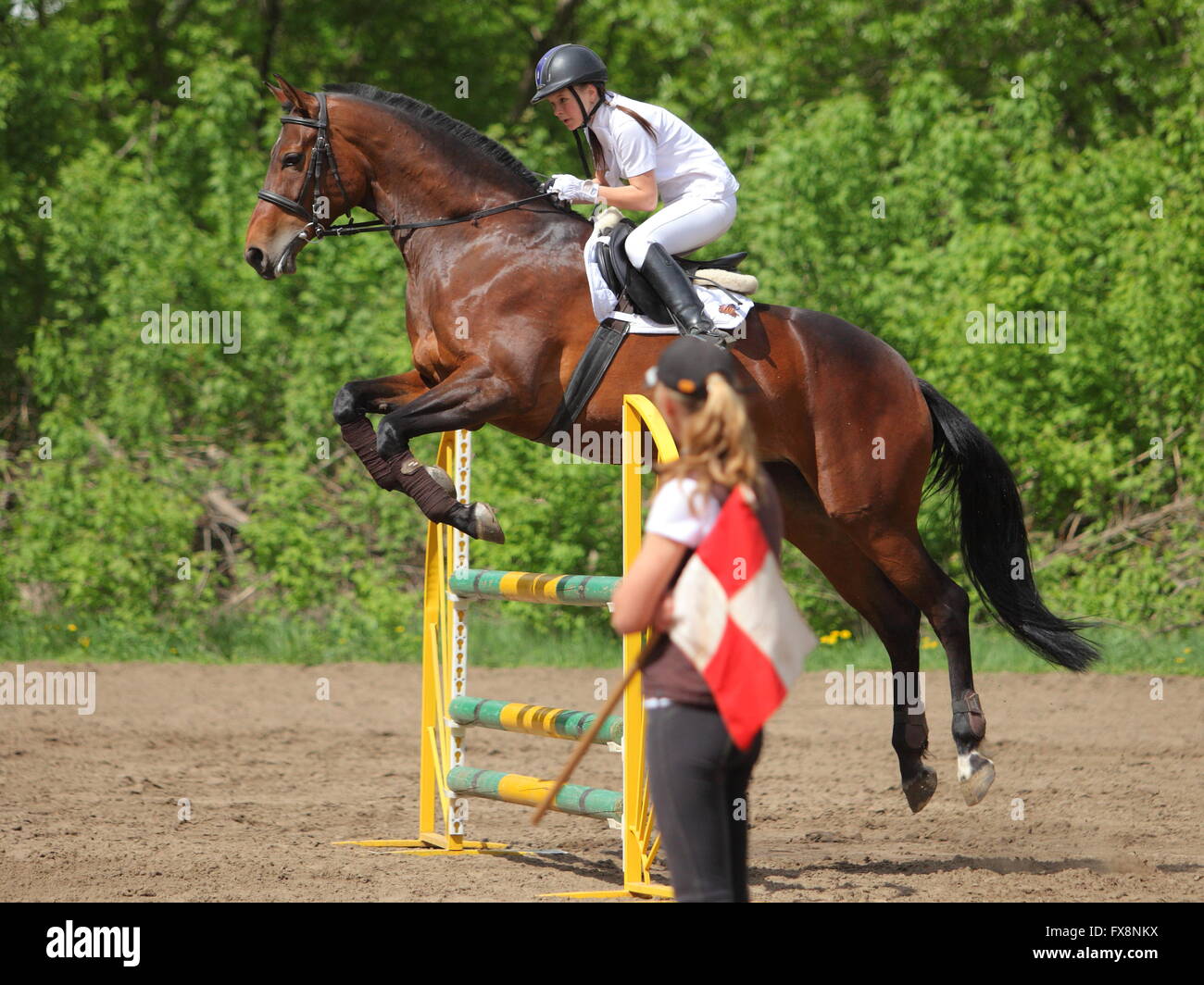 Mädchen im Pferdesport Uniform auf dem Pferderücken Hindernis springen ...