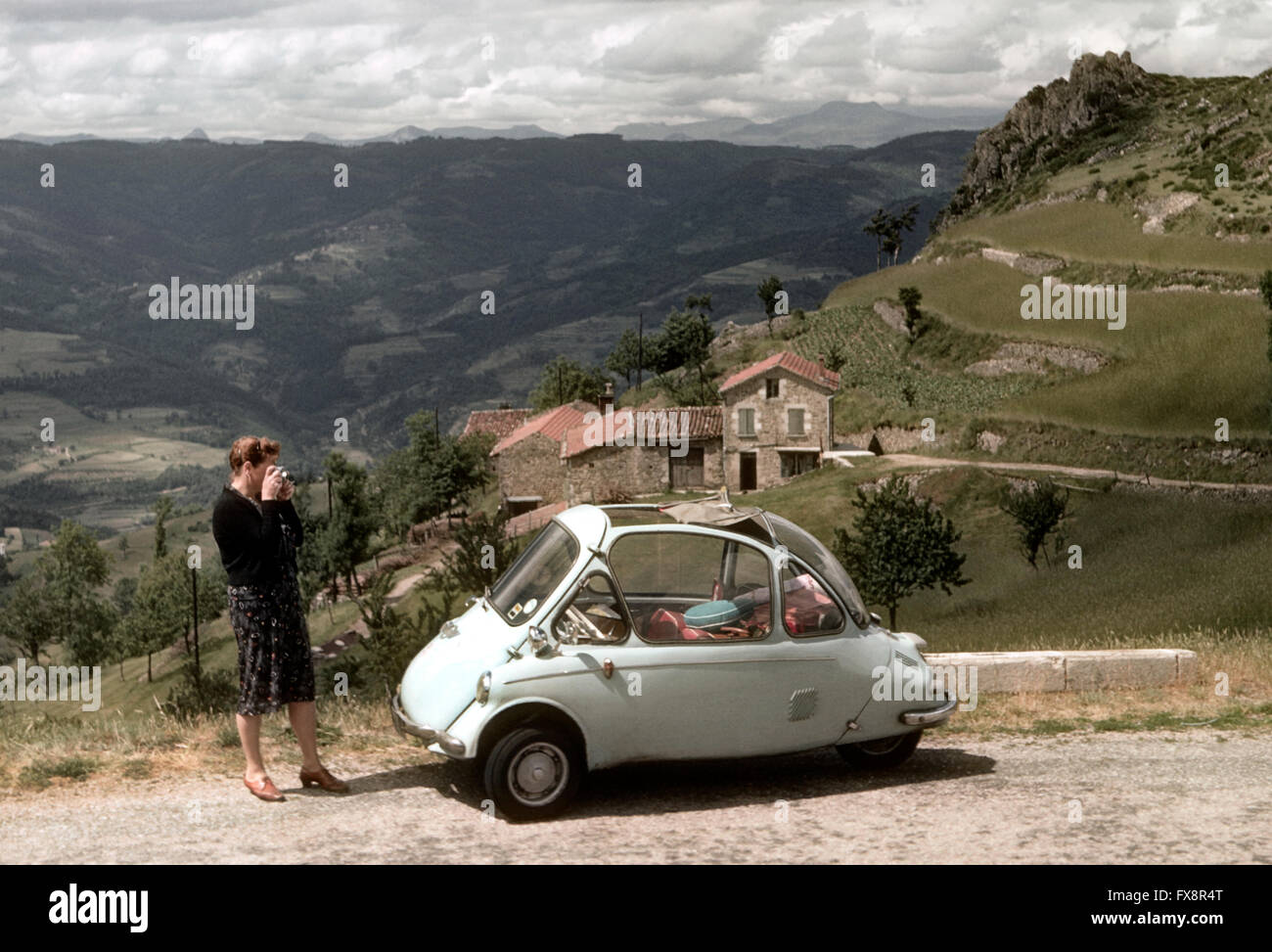 Frau nehmen Foto von 1963 auf Rädern Trojan 3 Auto abgebildet in Le Gerbier Region Frankreichs Stockfoto