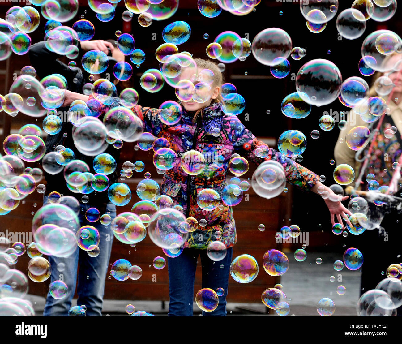 Prag, Tschechische Republik. Junges Mädchen am Altstädter Ring Spielen mit Luftblasen, die durch eine Straße Entertainer gemacht Stockfoto