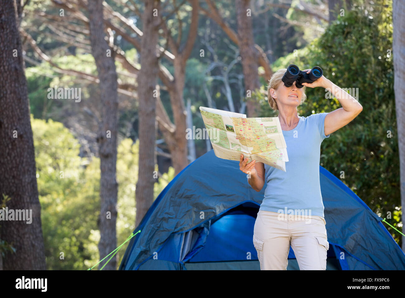 Reife Frau sucht bei Ferngläsern Stockfoto