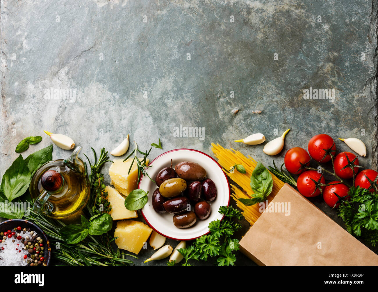 Italienische Küche Zutaten Hintergrund mit Spaghetti, Parmesan, Oliven, Öl und Basilikum Stockfoto