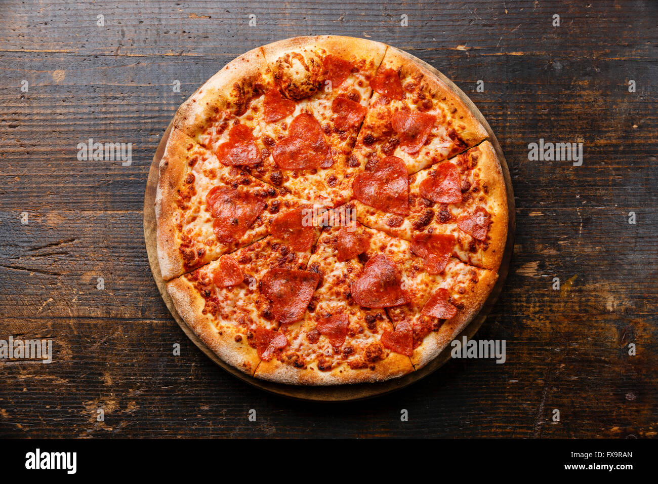 Herzform geschnitten Peperoni-Pizza auf hölzernen Hintergrund Stockfoto