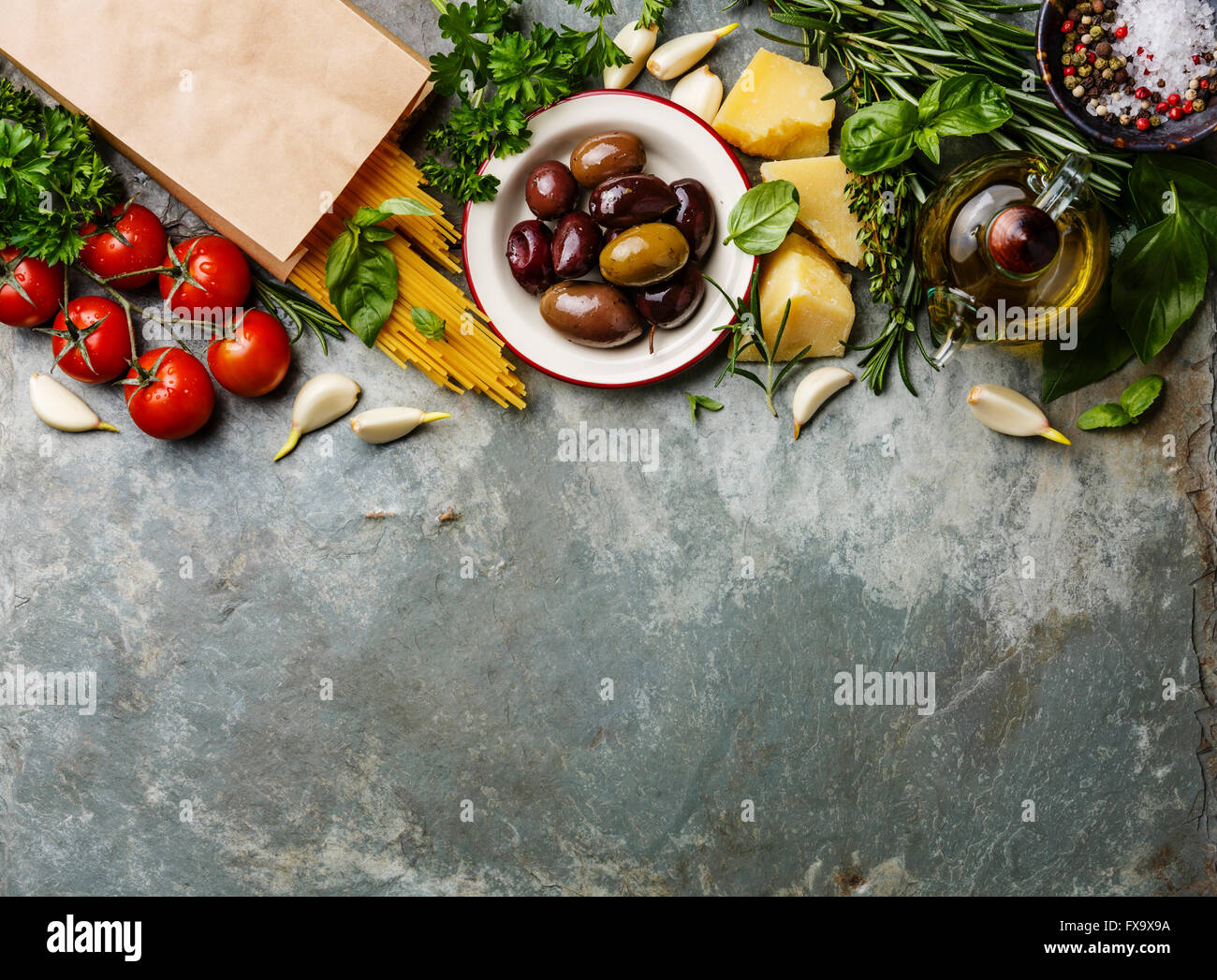 Italienische Küche Zutaten Hintergrund mit Spaghetti, Parmesan, Oliven, Öl und Basilikum Stockfoto