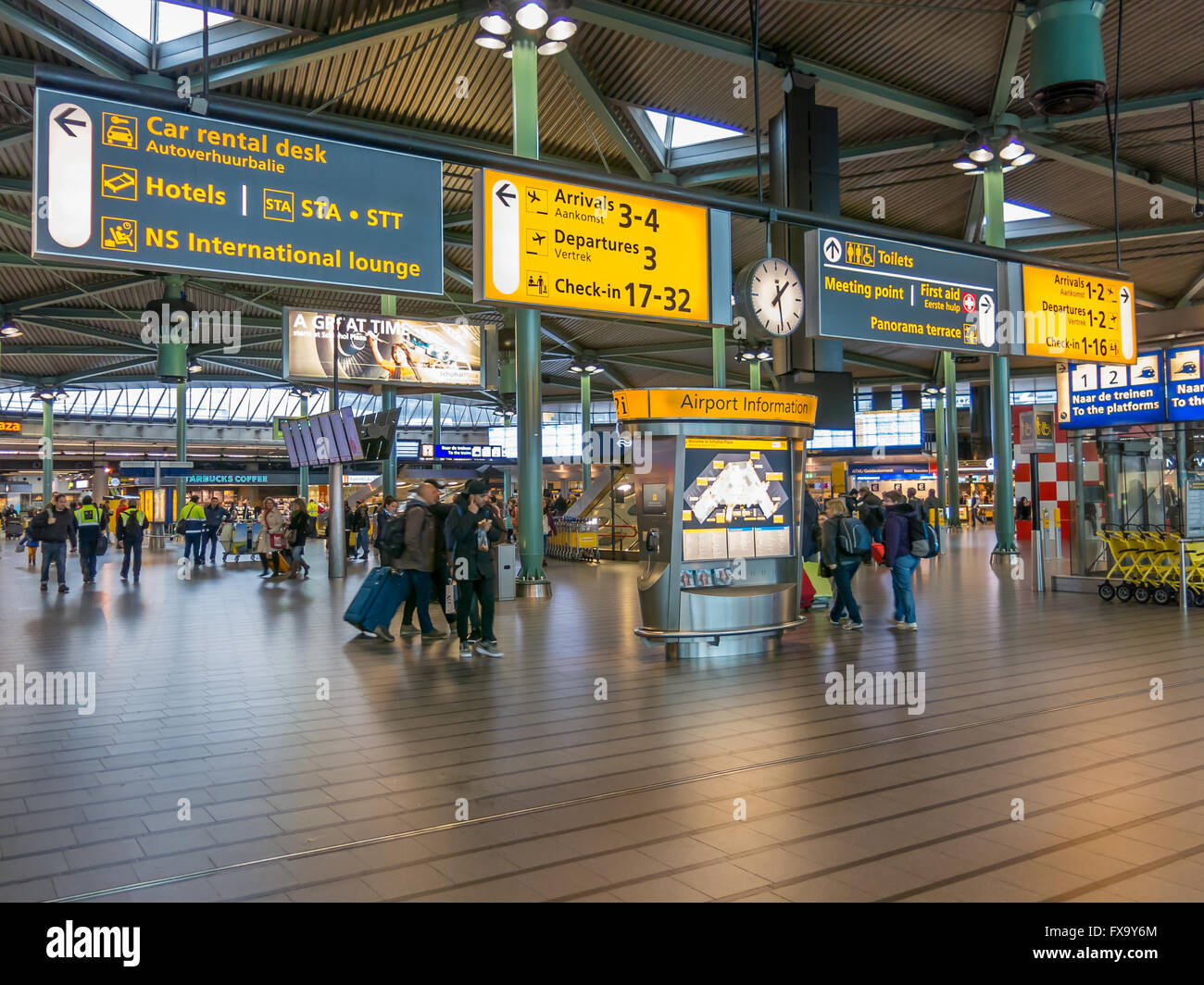 Informationstafeln und Menschen in Bahn-Terminal des Flughafen Schiphol, Niederlande Stockfoto