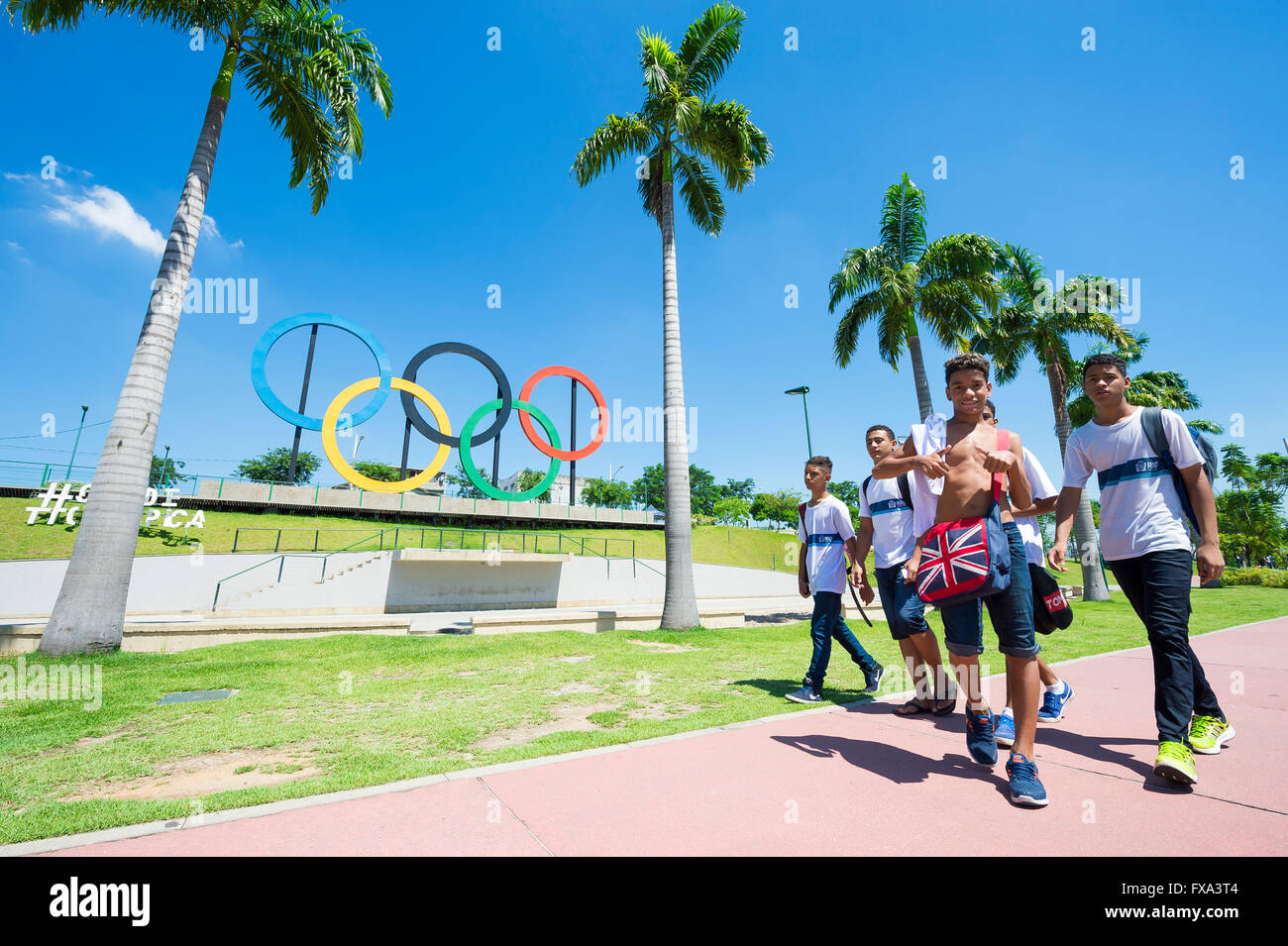 RIO DE JANEIRO - 18. März 2016: Junge Brasilianer laufen Sie vor Olympischen Ringe für die Olympischen Sommerspiele 2016 in einem Park installiert. Stockfoto