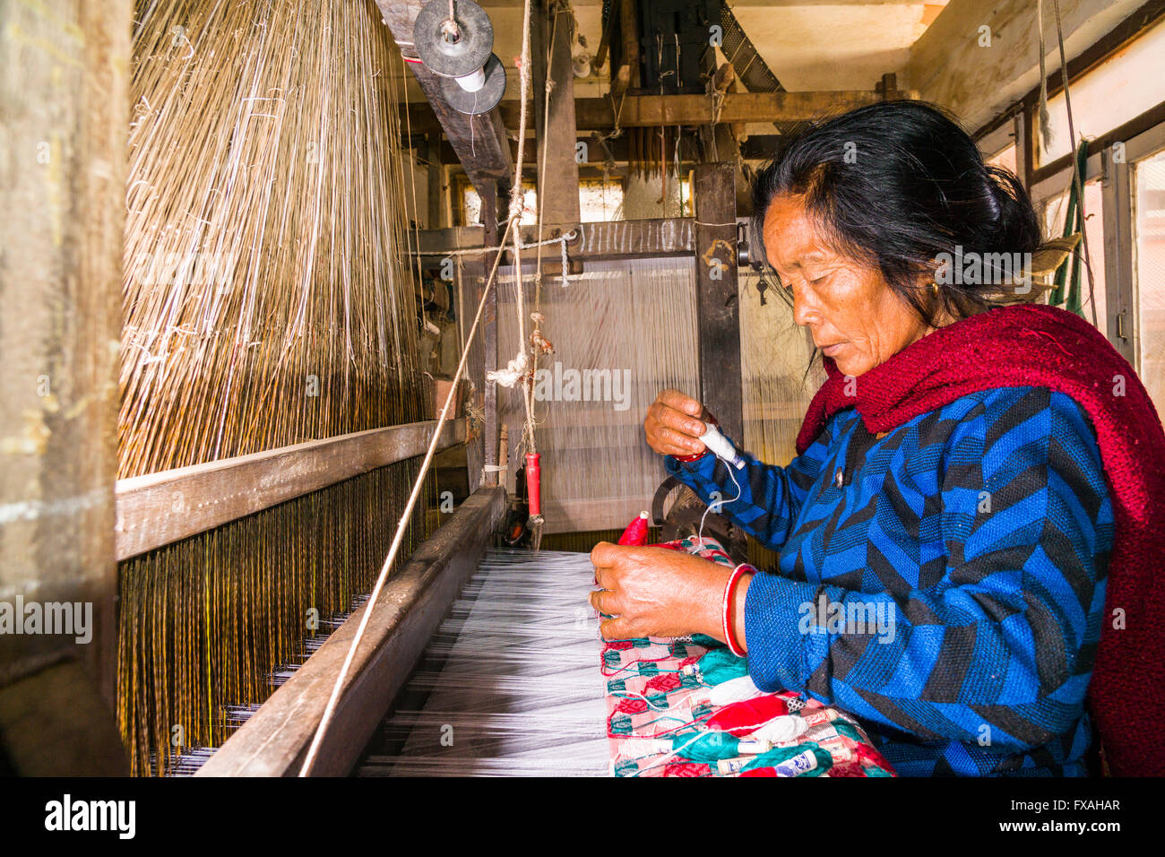 Eine Frau arbeitet an einem alten traditionellen Webstuhl Weben das Material für die Dhaka Topi, Nepali Trachtenhüte, Tansen Stockfoto