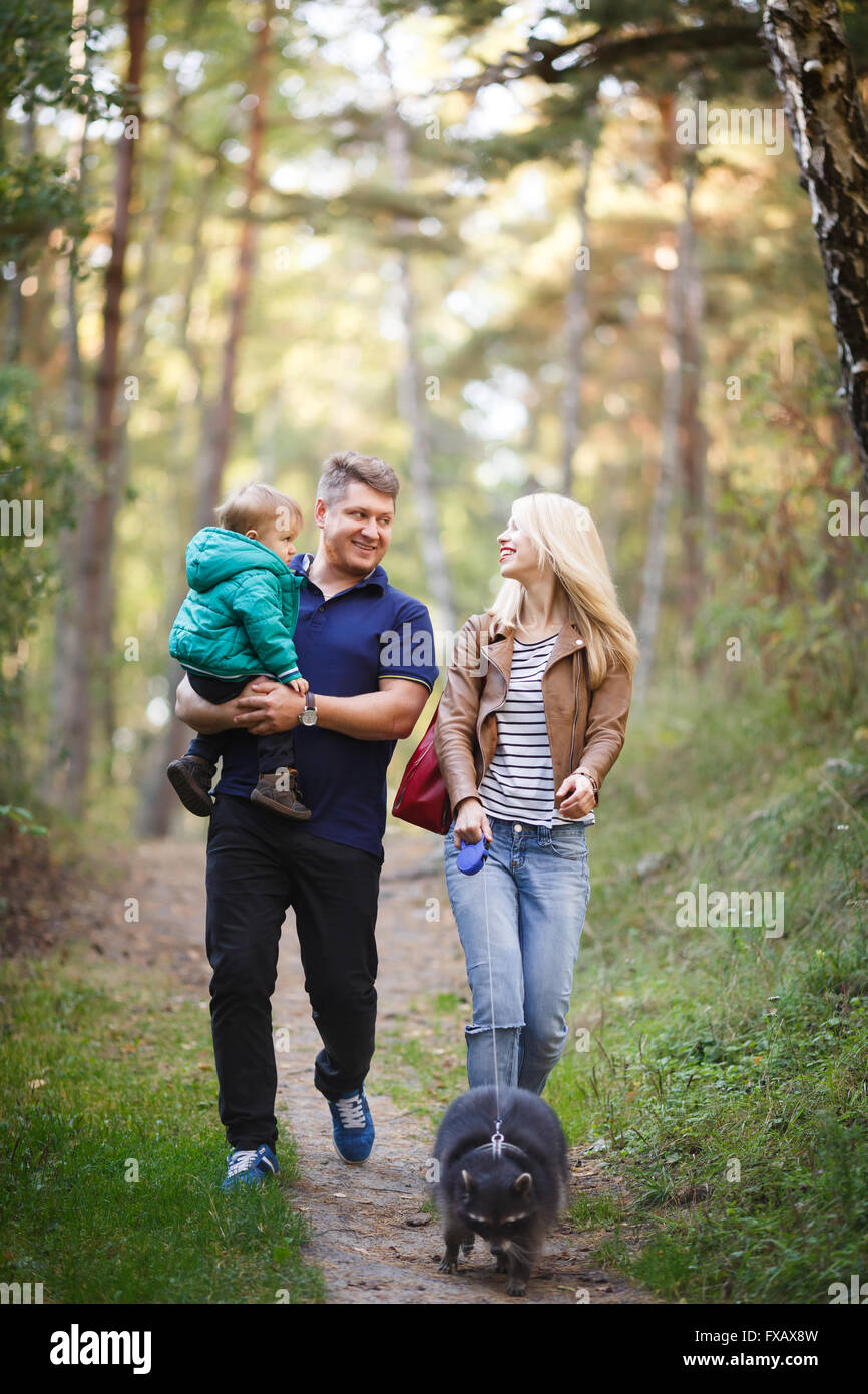 Glückliche Familie mit Waschbär zu Fuß in einem Wald Stockfoto