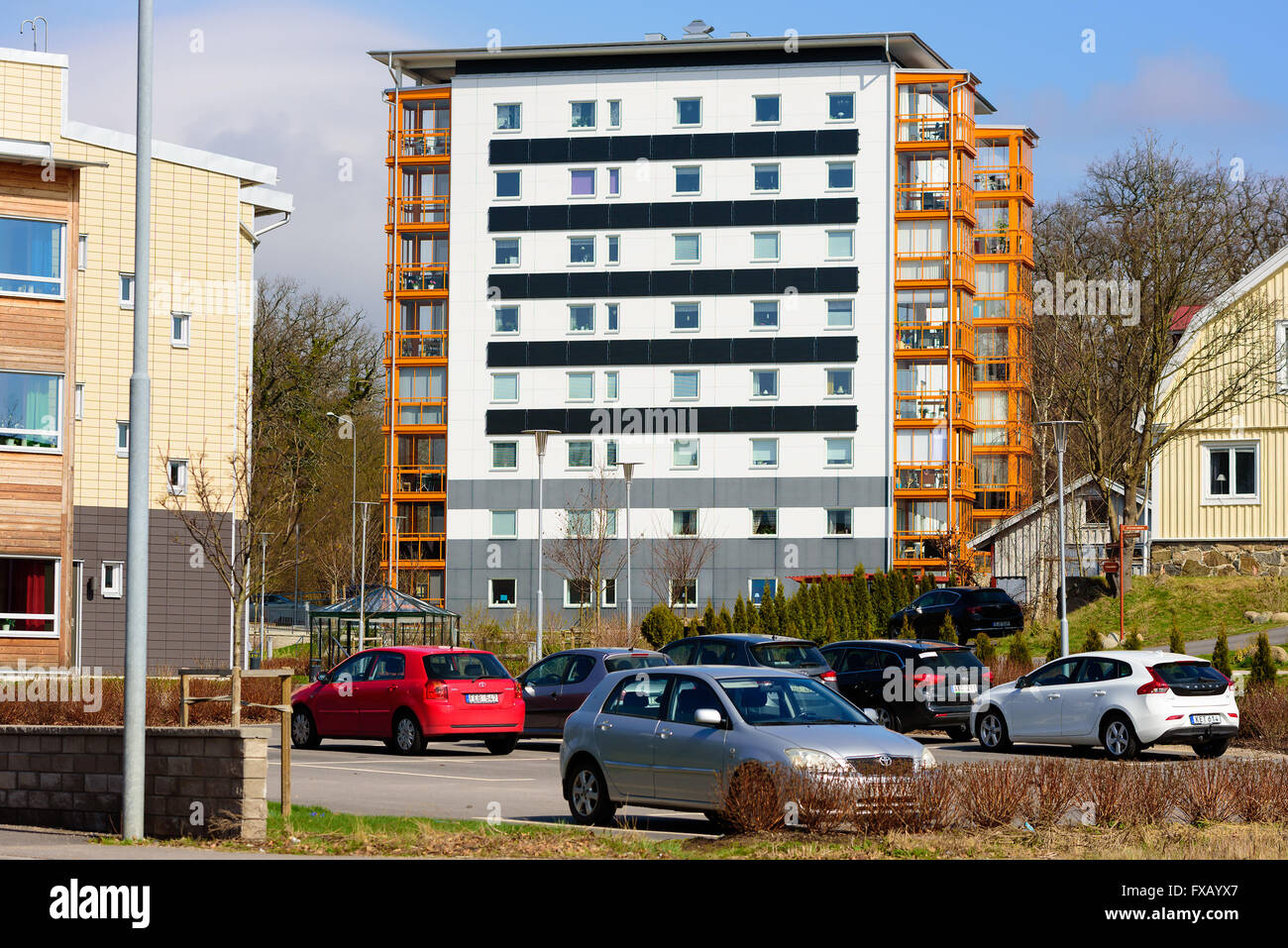 Ronneby, Schweden - April 7, 2016: 8-stöckiges, schwarzen und weißen Gebäude mit orangen Balkonen. Parkplatz vor. Stockfoto