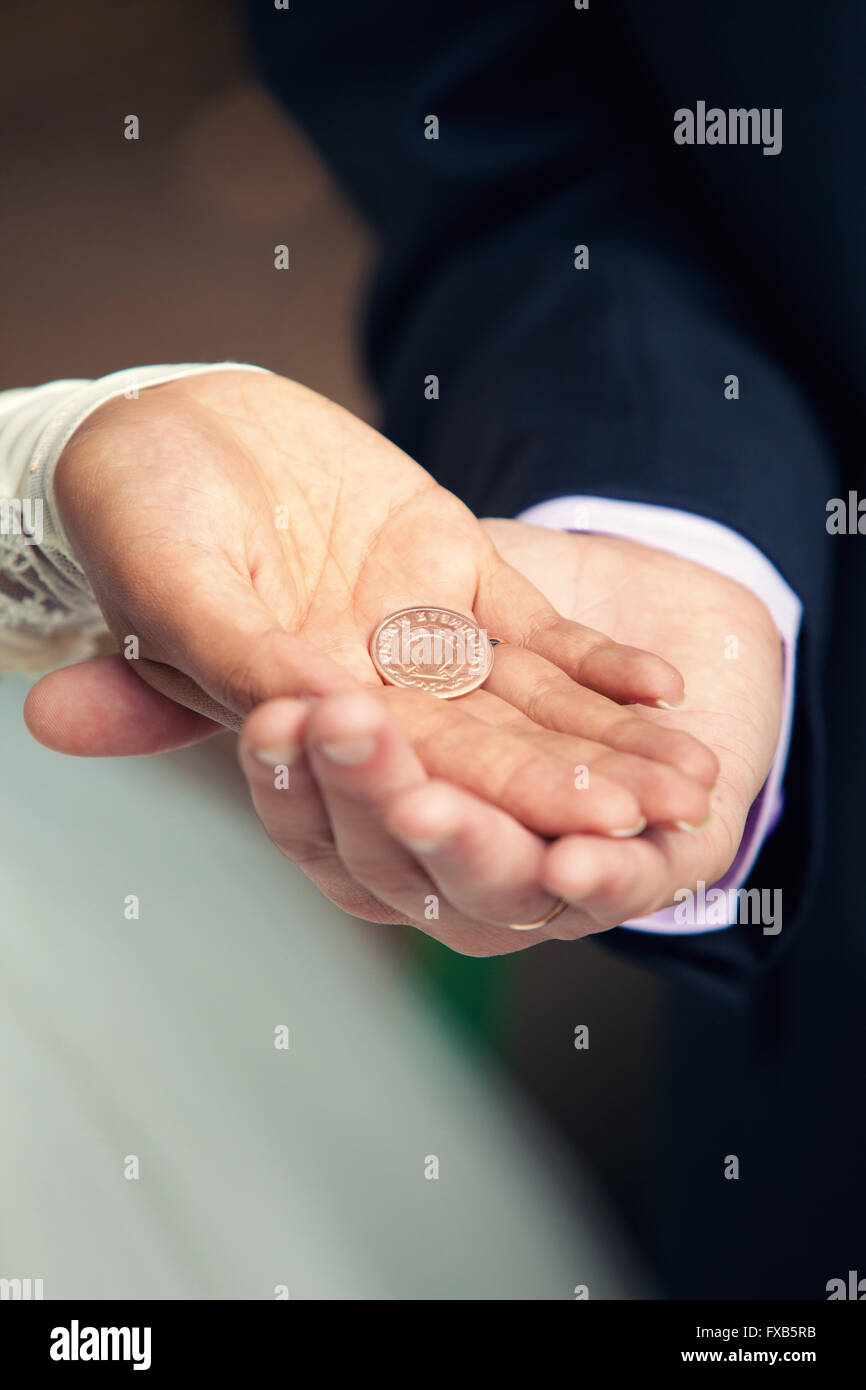 Großaufnahme Erfassung von einem frisch verheirateten Hände halten und alt glücklich Münze Stockfoto