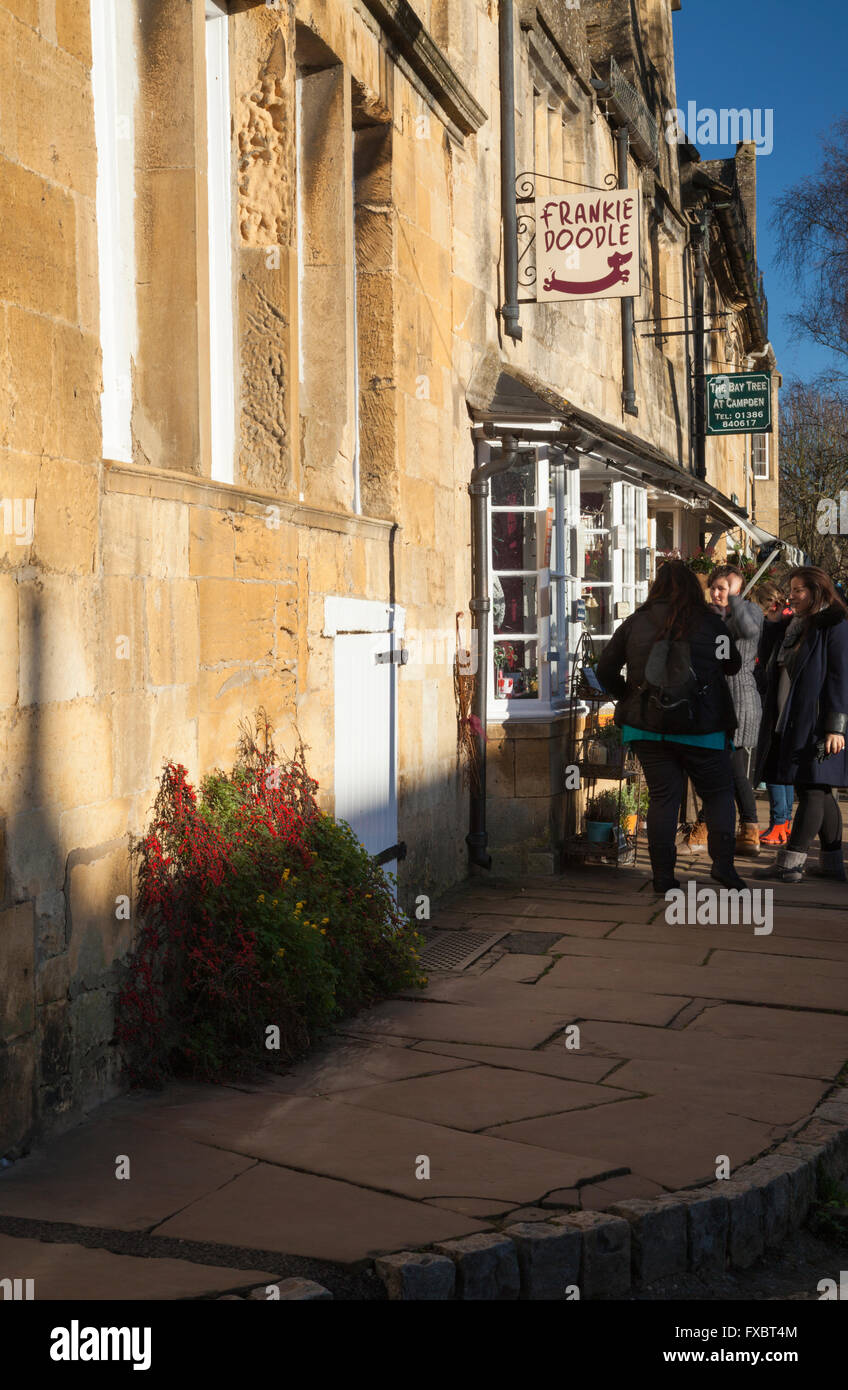 Gruppe von jungen weiblichen Touristen Schaufensterbummel in der High Street von Chipping Campden im Dezember, Cotswolds, Gloucestershire, England Stockfoto