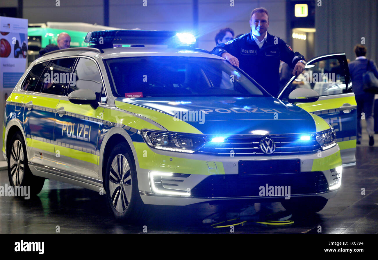 Leipzig, Deutschland. 14. April 2016. Rico Wiersig, stellvertretender Direktor der Leipziger Polizei Mitfahr-Börse, steht neben einer markierten Polizei-Hybrid-Fahrzeug, Fahrzeugmodell VW Passat GTE, während eine Konferenz zum Thema Elektromobilität in Leipzig, Deutschland, 14. April 2016. Die Bundesregierung hat eine 180 Millionen Euro-Programm zur Unterstützung der groß angelegte Nutzung Strom betriebene Fahrzeuge ins Leben gerufen. Vier Regionen in Deutschland wurden ausgewählt, um als Experimentierfeld für das Programm, mit dem Ergebnis bei der Konferenz in Leipzig präsentiert werden zu dienen. Foto: Jan Woitas/Dpa/Alamy Live News Stockfoto