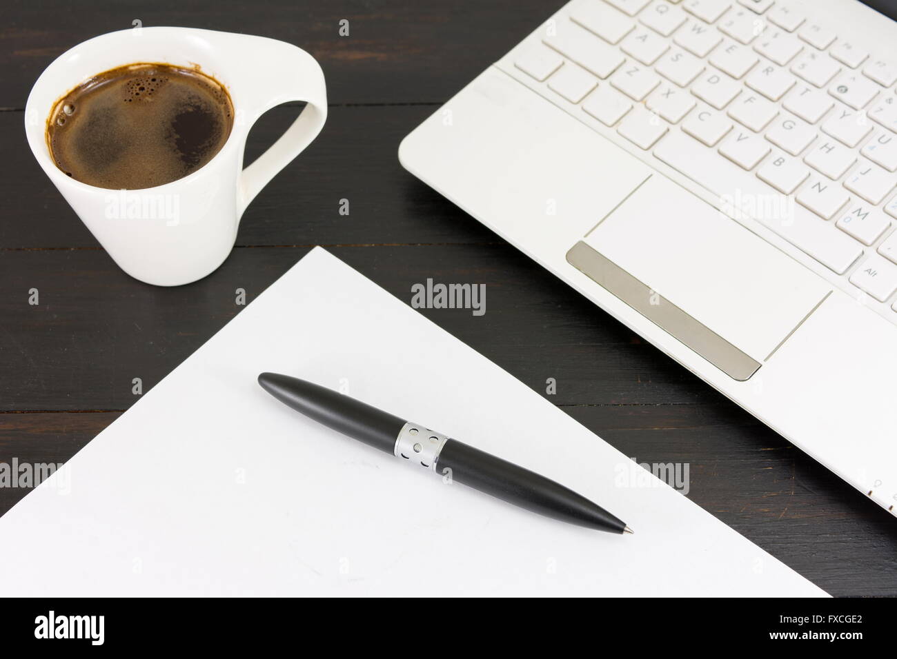 Tasse Kaffee für einen guten Arbeitstag. Kaffee und Tech Zubehör am schwarzen Tisch Stockfoto