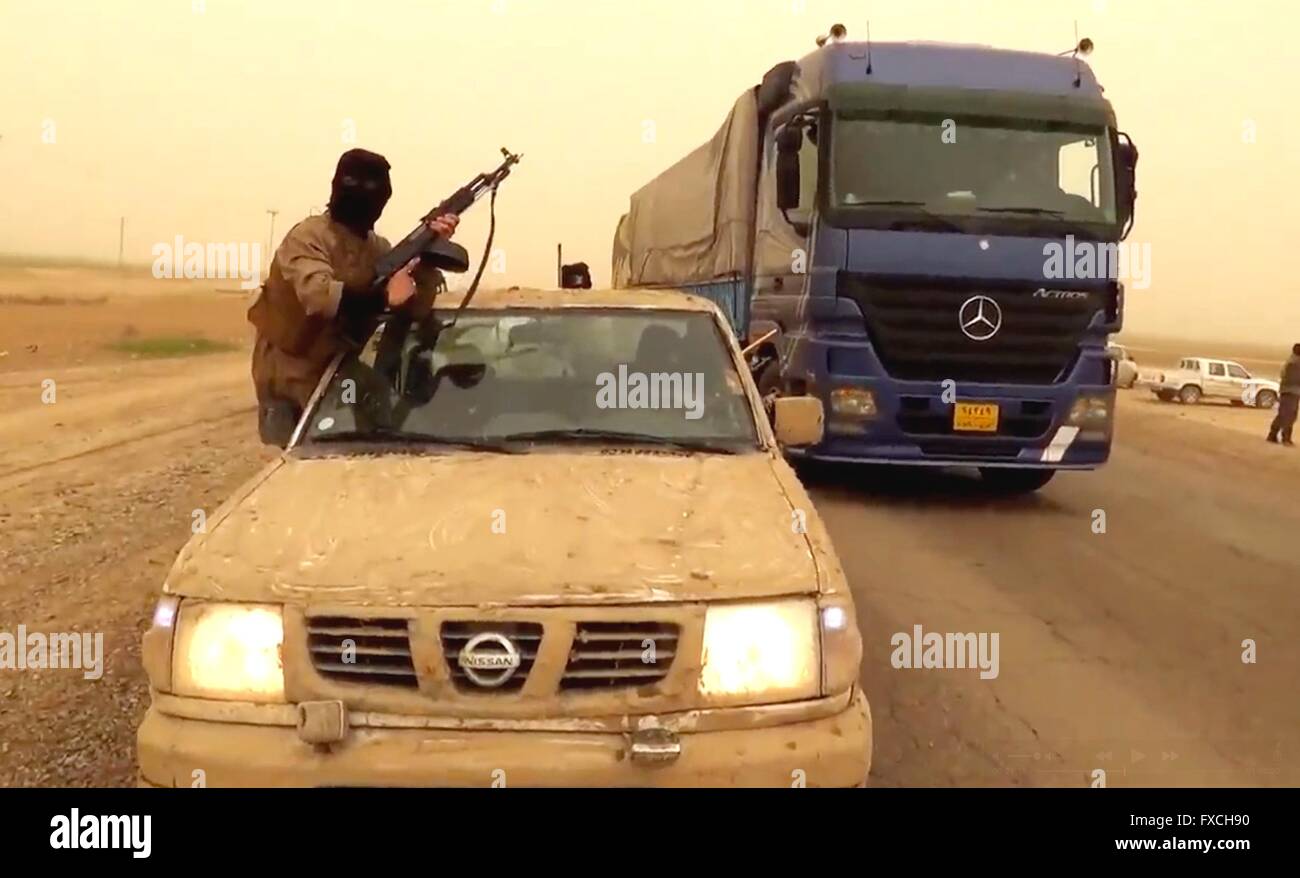 Eine islamischer Staat Kämpfer mans einen Check Point irakischen Regierungsvertretern und Offiziere entlang einer Autobahn in diesem undatierten Propaganda-video-Capture freigegeben durch die islamischen Staates im Irak und der Levante in der Provinz Anbar, Irak zu suchen. Stockfoto