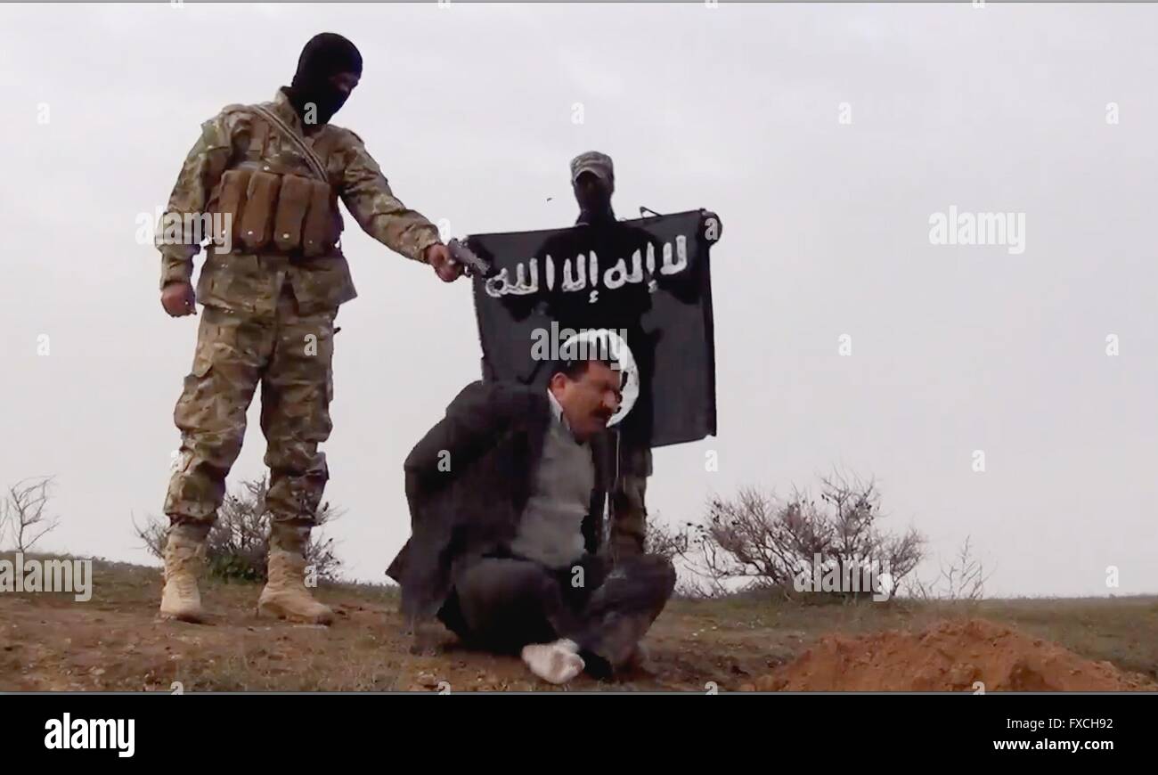 Eine islamischer Staat Kämpfer führt eine irakische Regierungsbeamten bei einem Kontrollposten entlang einer Autobahn in diesem undatierten Propaganda-video-Capture freigegeben durch die islamischen Staates im Irak und der Levante in der Provinz Anbar, Irak gefunden. Stockfoto