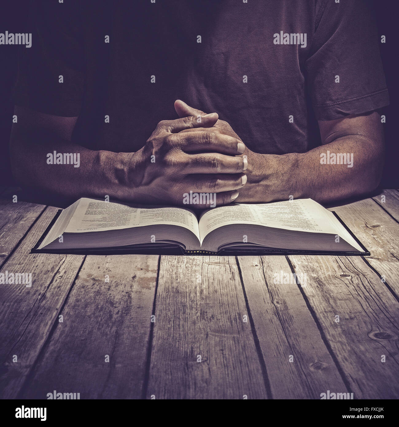 Mann, Studium der Heiligen Schrift auf einem Holztisch. Stockfoto