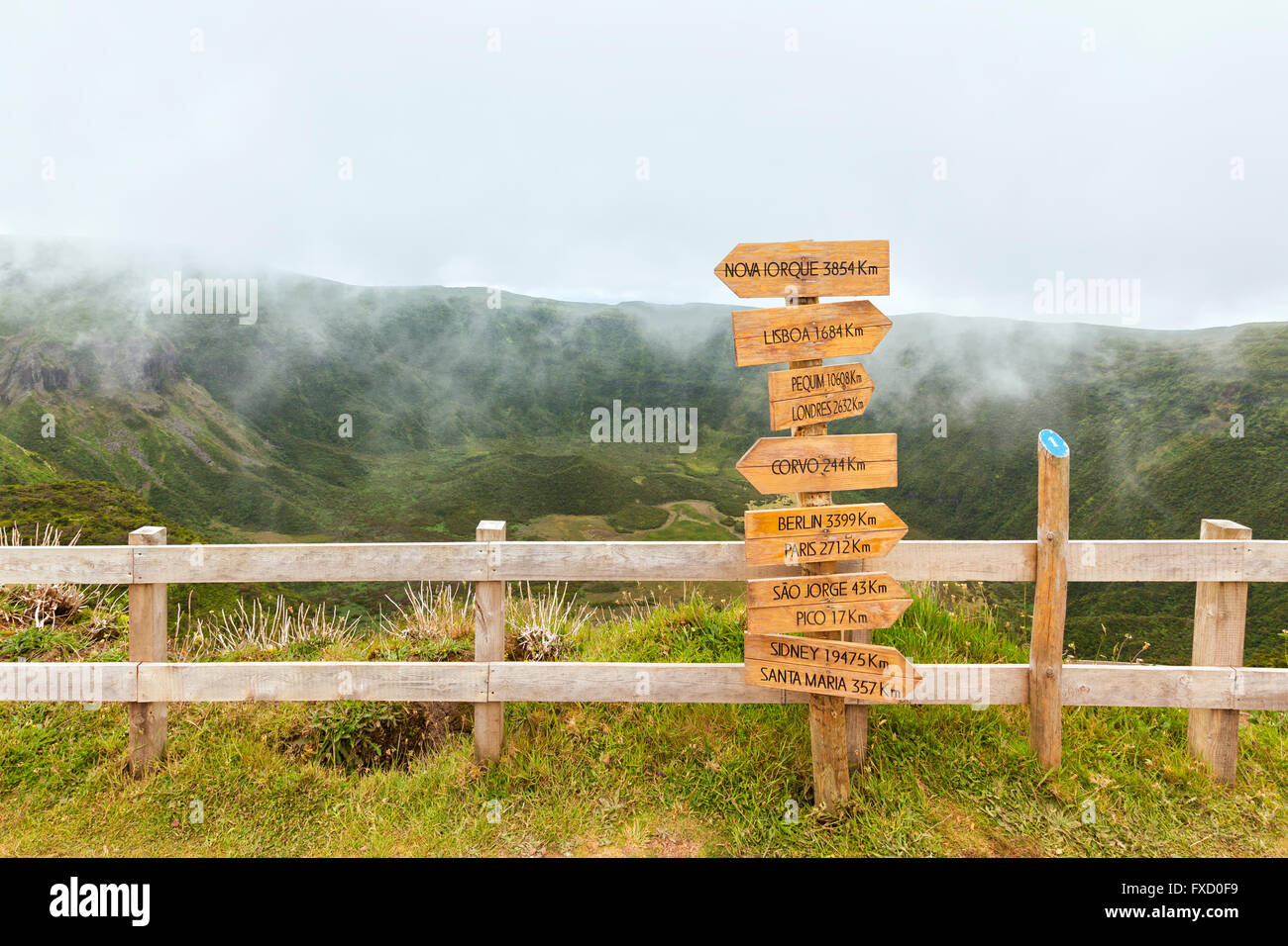 Richtungsanzeiger zeigt Entfernungen zu weltweiten Standorten am Cabeço Gordo, Faial Insel, Azoren, Caldera im Hintergrund Stockfoto