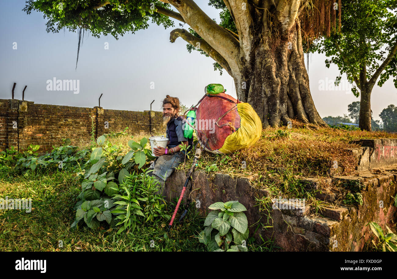 Wandernde Sadhu Baba (Heiliger) mit traditionellen langen Haaren und eine große Tasche Stockfoto