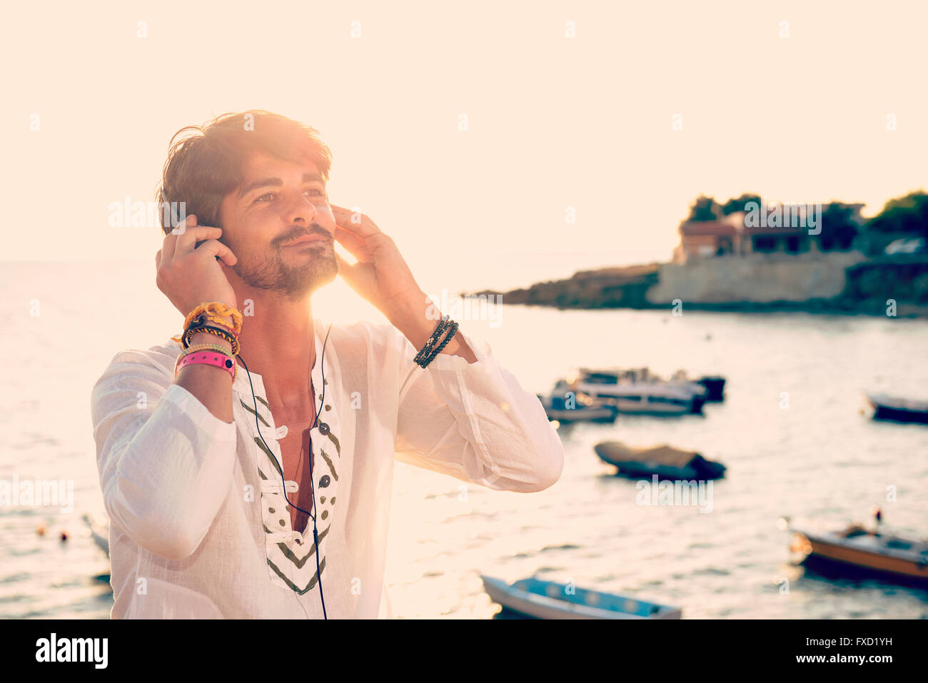 Kerl Musik hören mit Kopfhörern aus Tablet in einer Ferien-destination Stockfoto