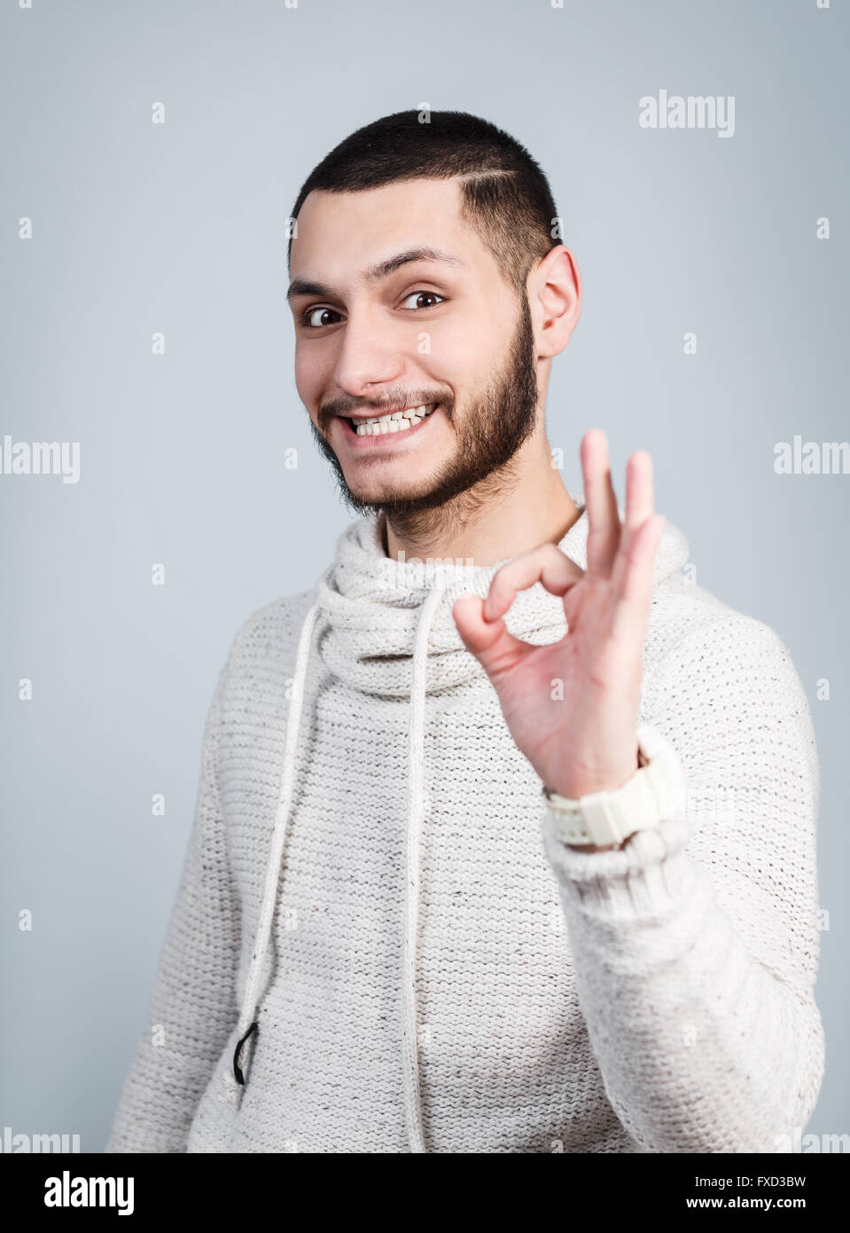 Schöner junger Mann zeigt OK Sign. Stockfoto