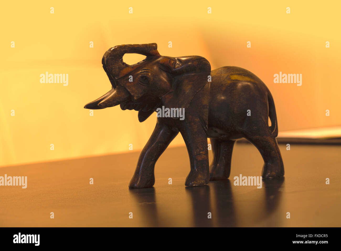 Antik-Stein Nashorn Figur mit zwei Hörnern und zu Fuß auf einem schwarzen Tisch. Stockfoto