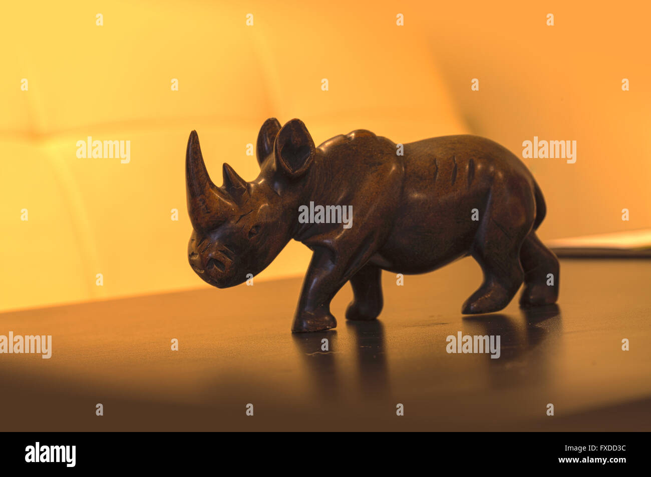 Antik-Stein Nashorn Figur mit zwei Hörnern und zu Fuß auf einem schwarzen Tisch. Stockfoto