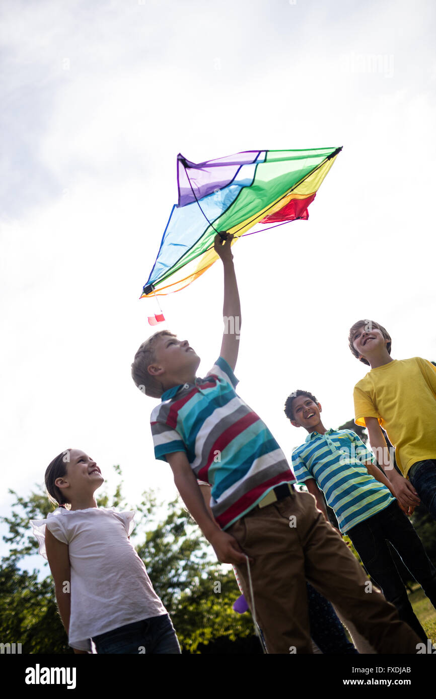 Glückliche Kinder spielen mit einem Drachen Stockfoto