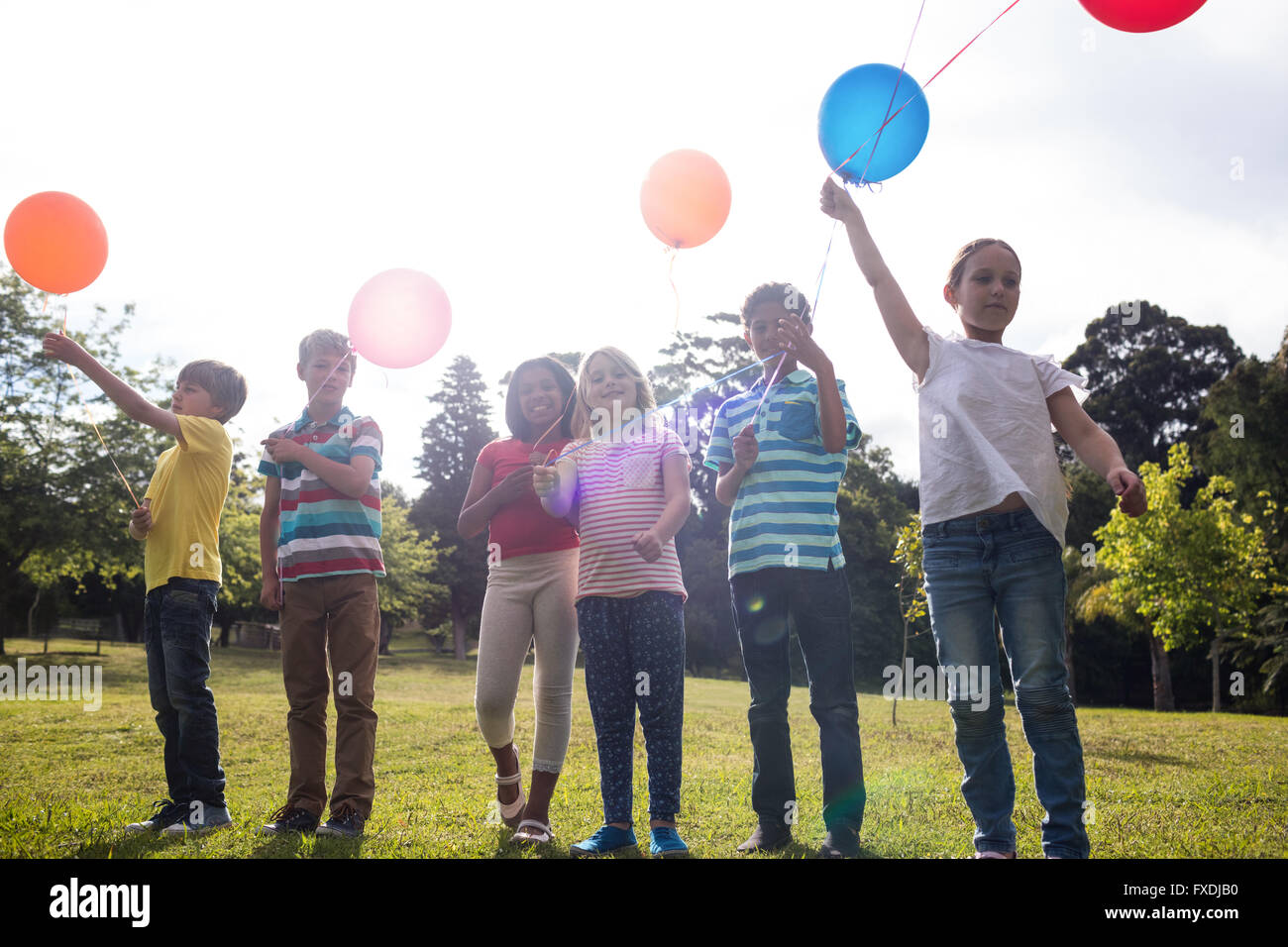 Glückliche Kinder, die spielen mit Luftballons in den park Stockfoto