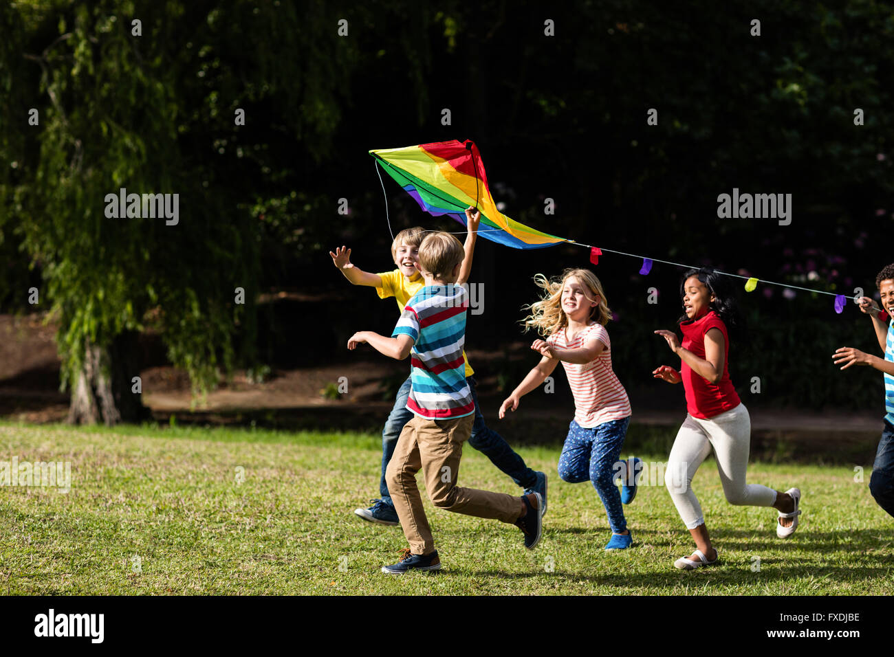 Glückliche Kinder spielen mit einem Drachen Stockfoto