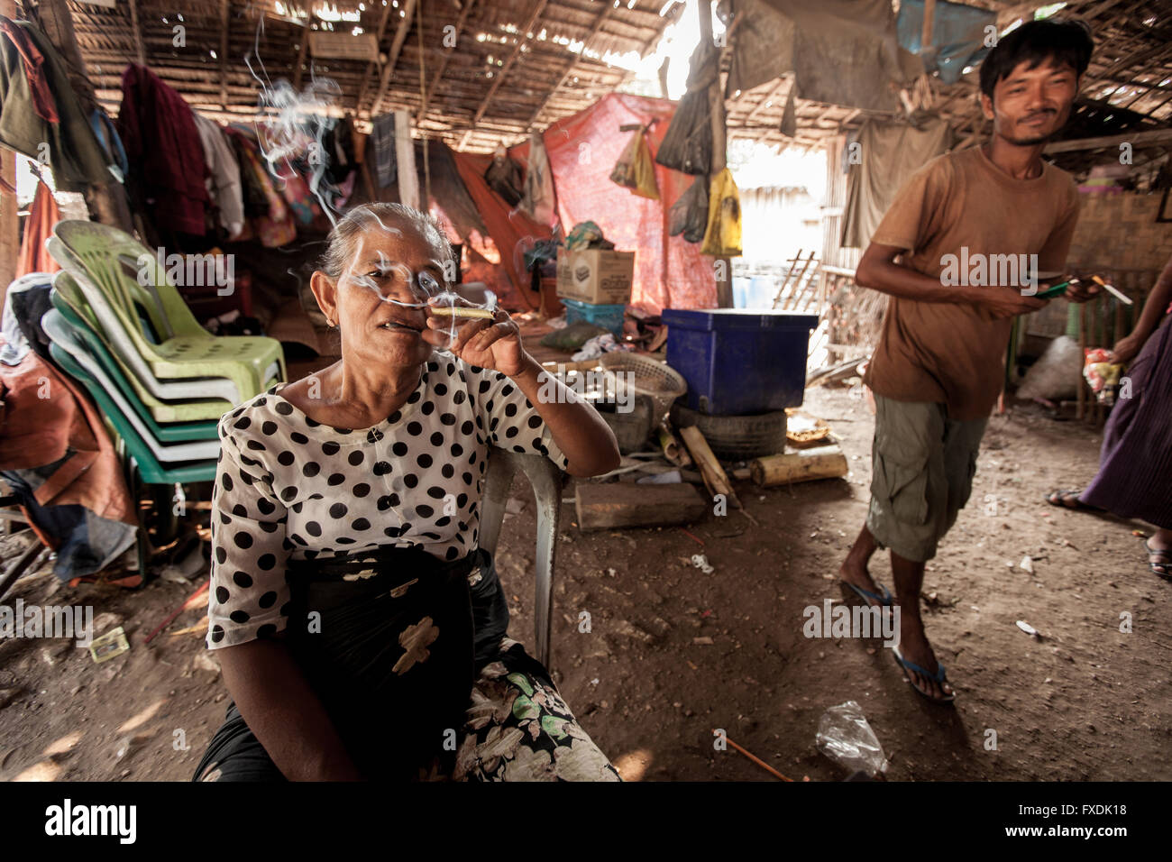 Myanmar, Asien, einem typischen Haus des Meeres Zigeunerfamilie, Großmutter qualmender Zigarette und Mann lächelnd. Stockfoto