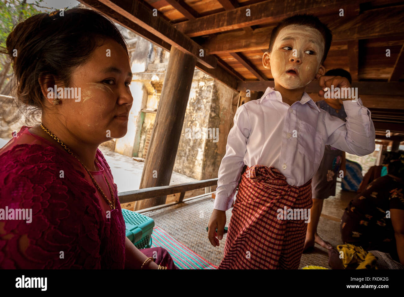 Myanmar, Asien, Mutter und junge zu Hause auf der Terrasse spielen, hat der junge eine gemalte in weißes Gesicht. Stockfoto
