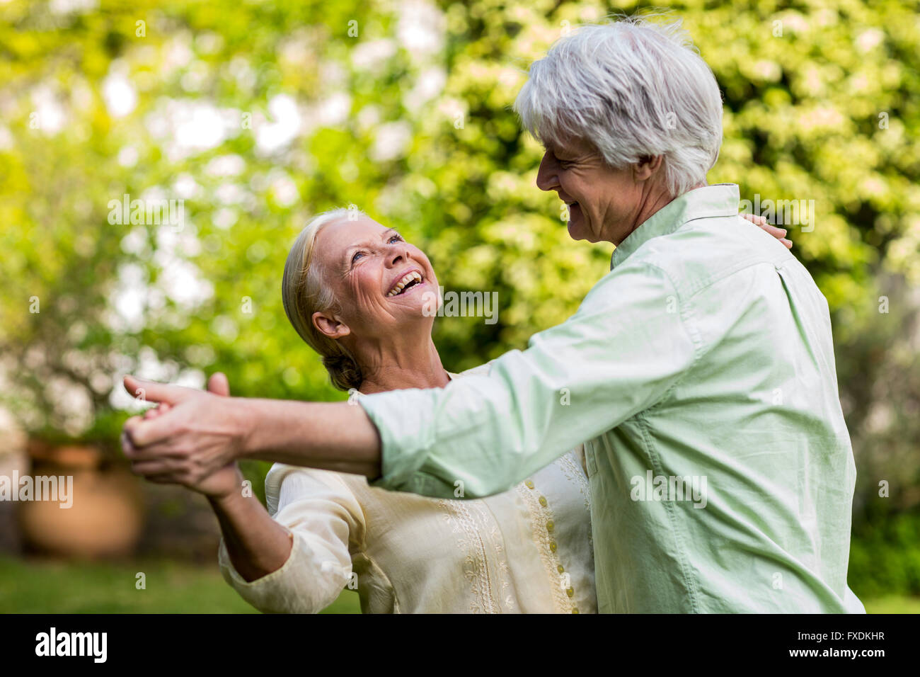 Ältere Frau beim Tanzen mit Mann blickte lächelnd Stockfoto