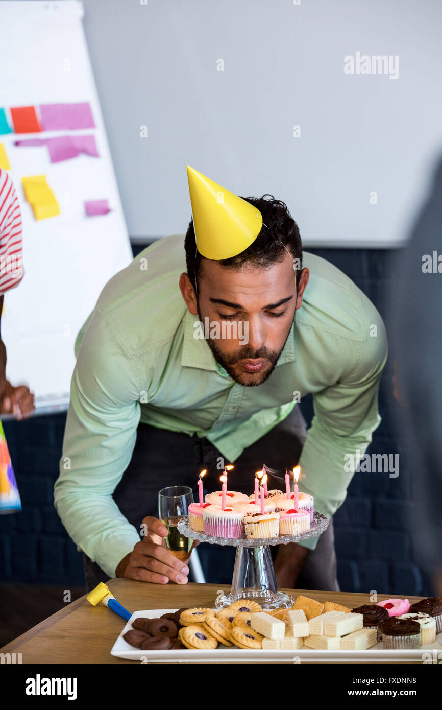 Mann bläst Kerzen an seinem Geburtstag Kuchen Stockfoto