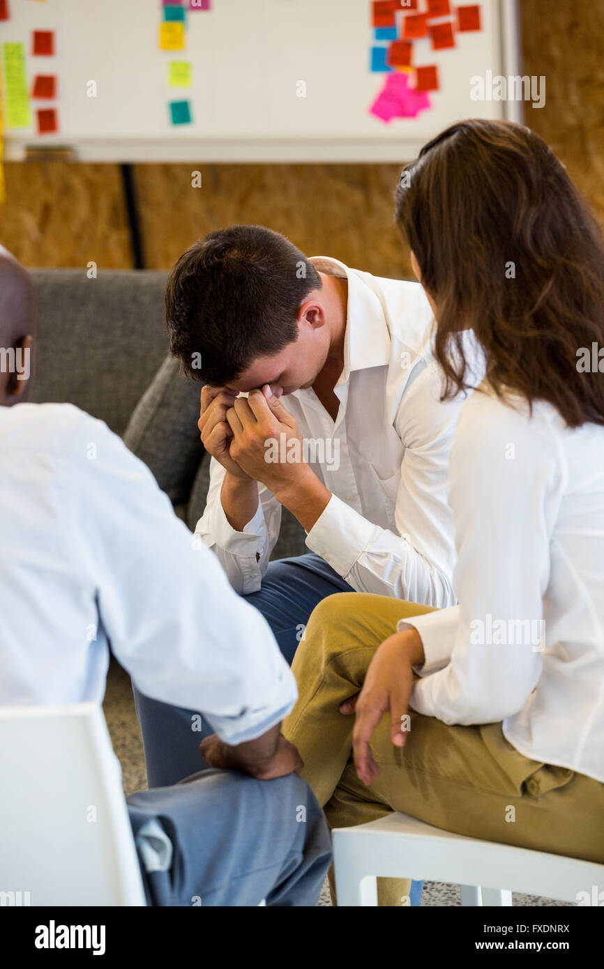 Unglücklichen Mann runzelte die Stirn und ein Gespräch mit ihren Kollegen Stockfoto