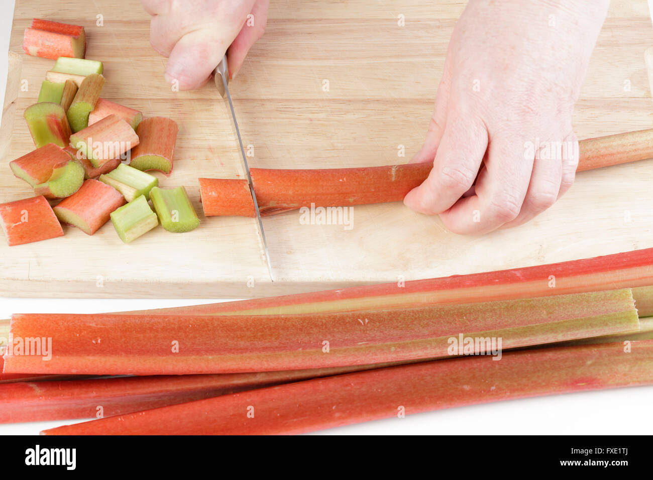 Hände schneiden Rhabarber in der Küche Stockfoto