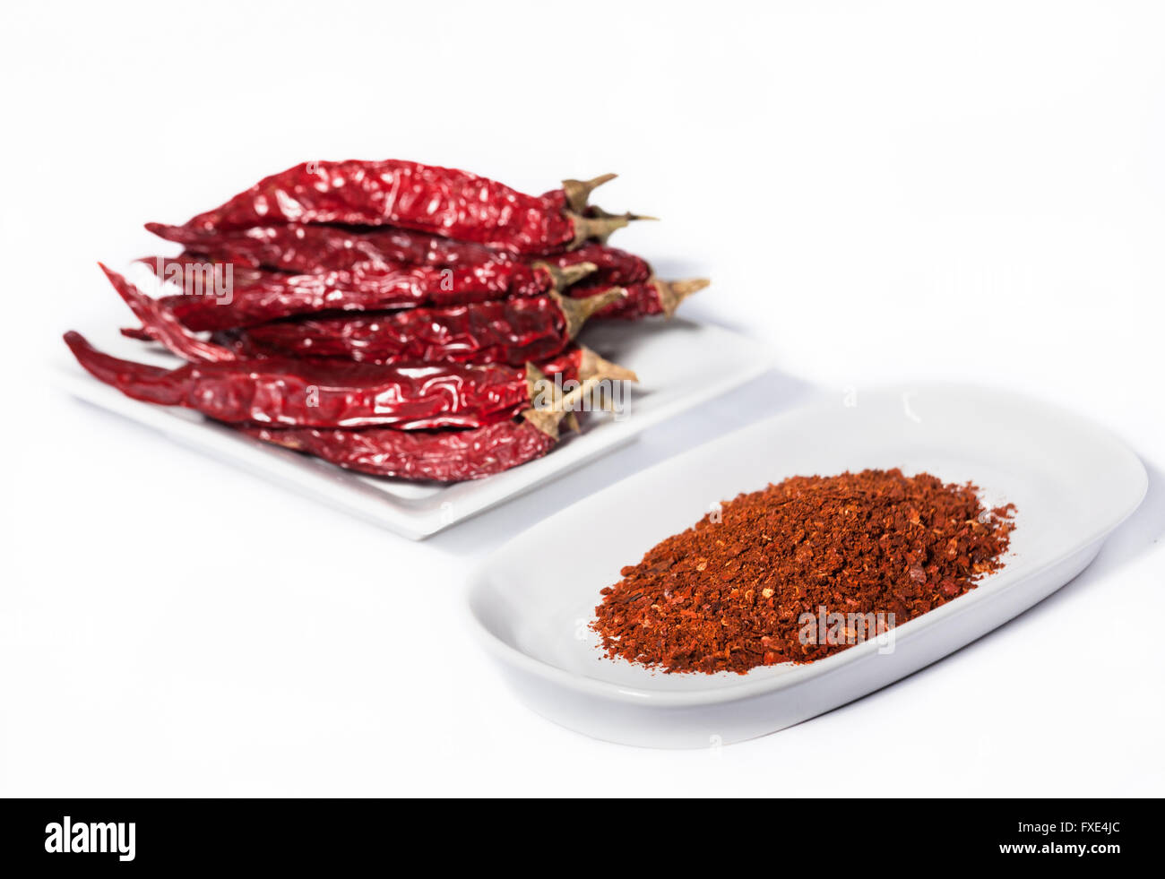 Studio Fotografie Bild der Getrocknete rote Chilis und scharfe rote Chili Pulver auf weißem Hintergrund in diesem Essen Fotografie Foto von Oriental Spice isoliert Stockfoto