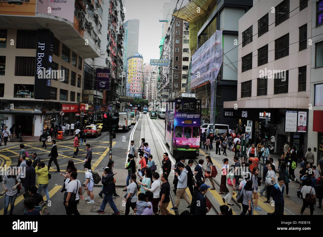 Menschen Überqueren der Straße in beliebten Causeway Bay in Hongkong. Bunte Straßenbahn im Hintergrund. Buch Cover Stockfoto