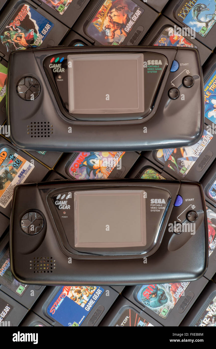Zwei Sega Game Gear Videospiel Einheiten - die Originalversion von 1990 und die Majesco Version von 2001 - auf einem Bett von Patronen. Stockfoto