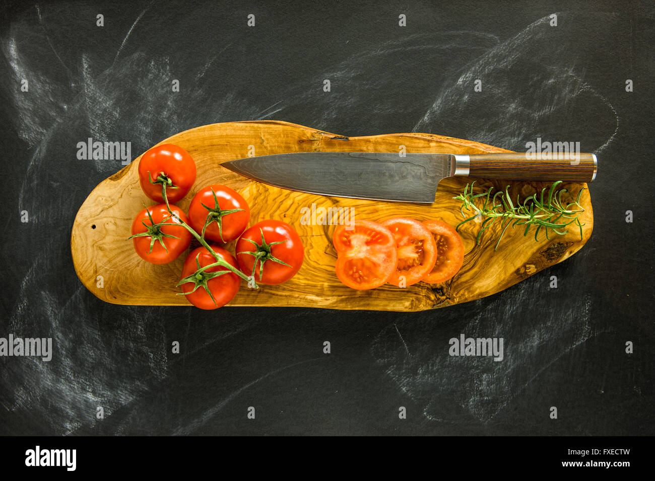Tomaten auf Holzbrett mit Damaskus Messer. Stockfoto
