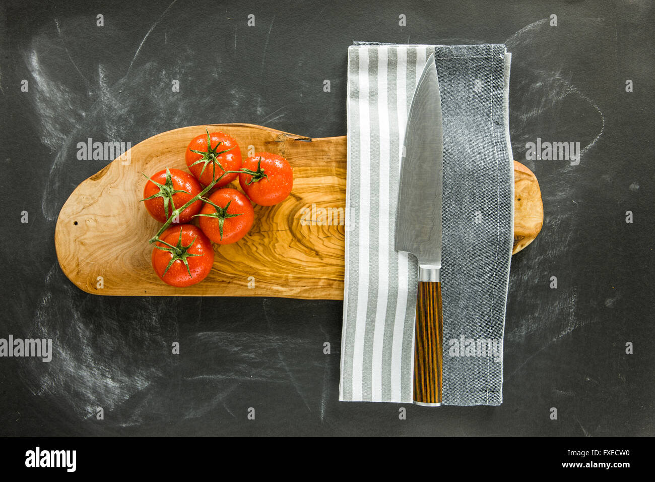 Jede Menge Tomaten und Damaskus Messer auf Holzbrett. Stockfoto