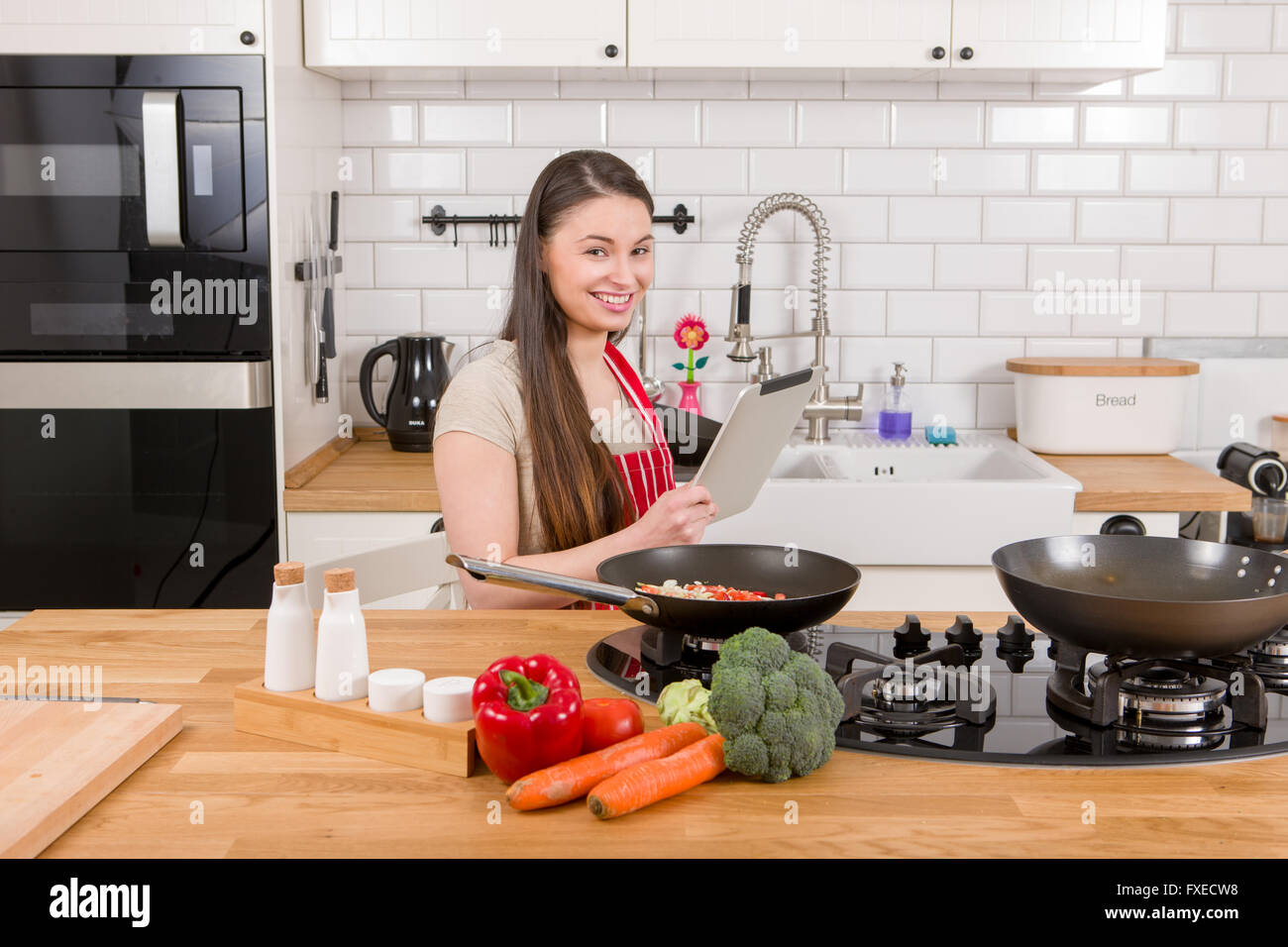 Kaukasische attraktive Frau mit Tablet-PC in der Küche. Stockfoto
